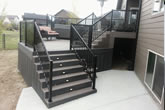 Stairs and composite deck with glass railings.