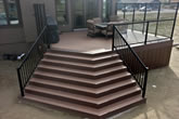 Stairs and composite deck with glass railings.